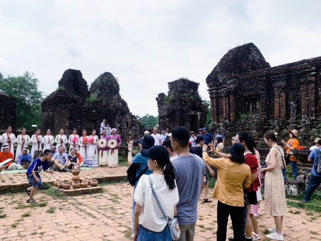 Du khách chụp hình điệu múa Chăm ở di tích Mỹ Sơn để lưu niệm. Ảnh: Ban QLDSVH Mỹ Sơn cũng cấp