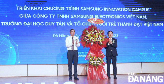 Chủ tịch UBND thành phố Lê Trung Chinh (bên trái) tặng hoa cho ông Choi Joo Ho - Tổng Giám đốc Samsung Việt Nam tại lễ ký kết. Ảnh: NGỌC HÀ