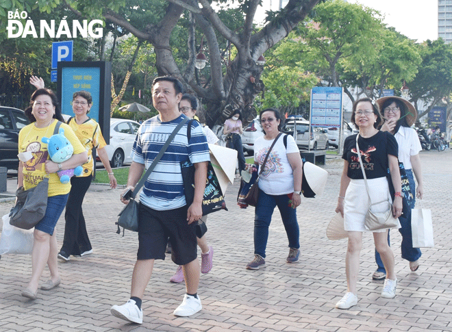 Tại Lễ hội pháo hoa quốc tế Đà Nẵng DIFF 2023, du khách có nhiều lựa chọn để xem các màn trình diễn pháo hoa. Trong ảnh: Du khách đi dạo dọc bờ sông Hàn (đường Bạch Đằng). Ảnh: N.H