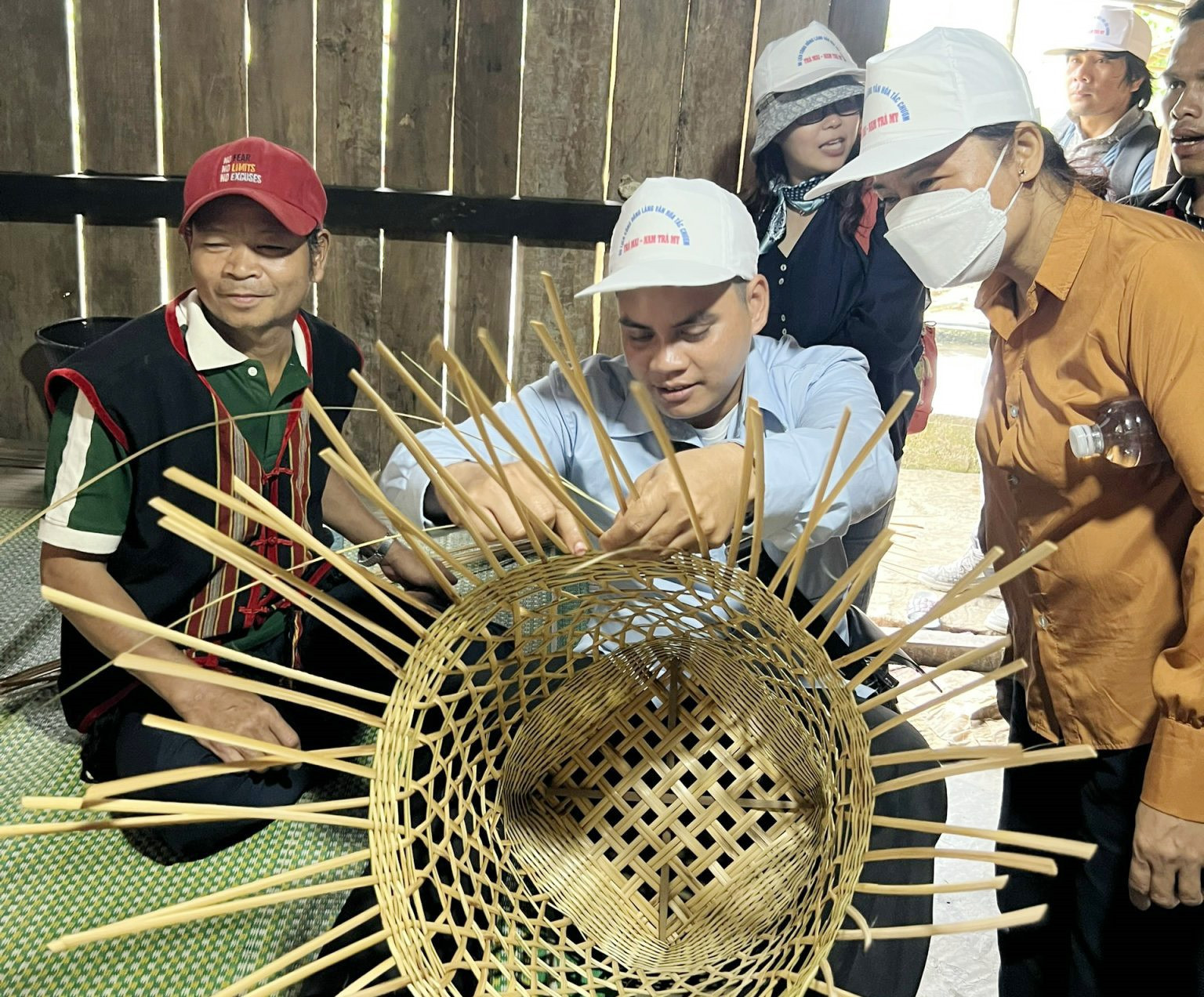 Du khách cùng tham gia nghề đan lát truyền thống với người dân. Ảnh: D.L