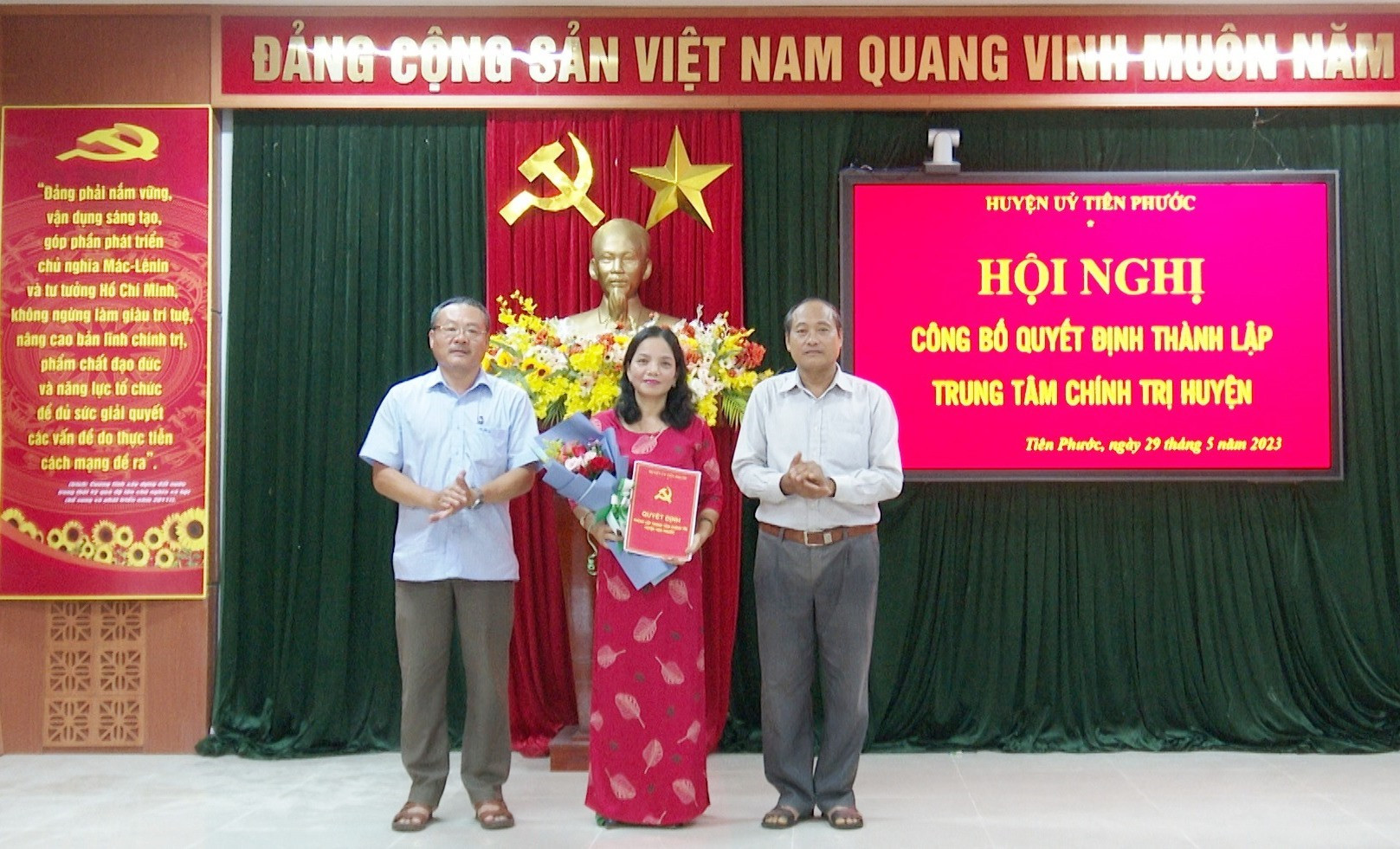 Lãnh đạo huyện Tiên Phước trao quyết định và tặng hoa chúc mừng đồng chí Trần Thị Thu Ba - Giám đốc Trung tâm Chính trị huyện.