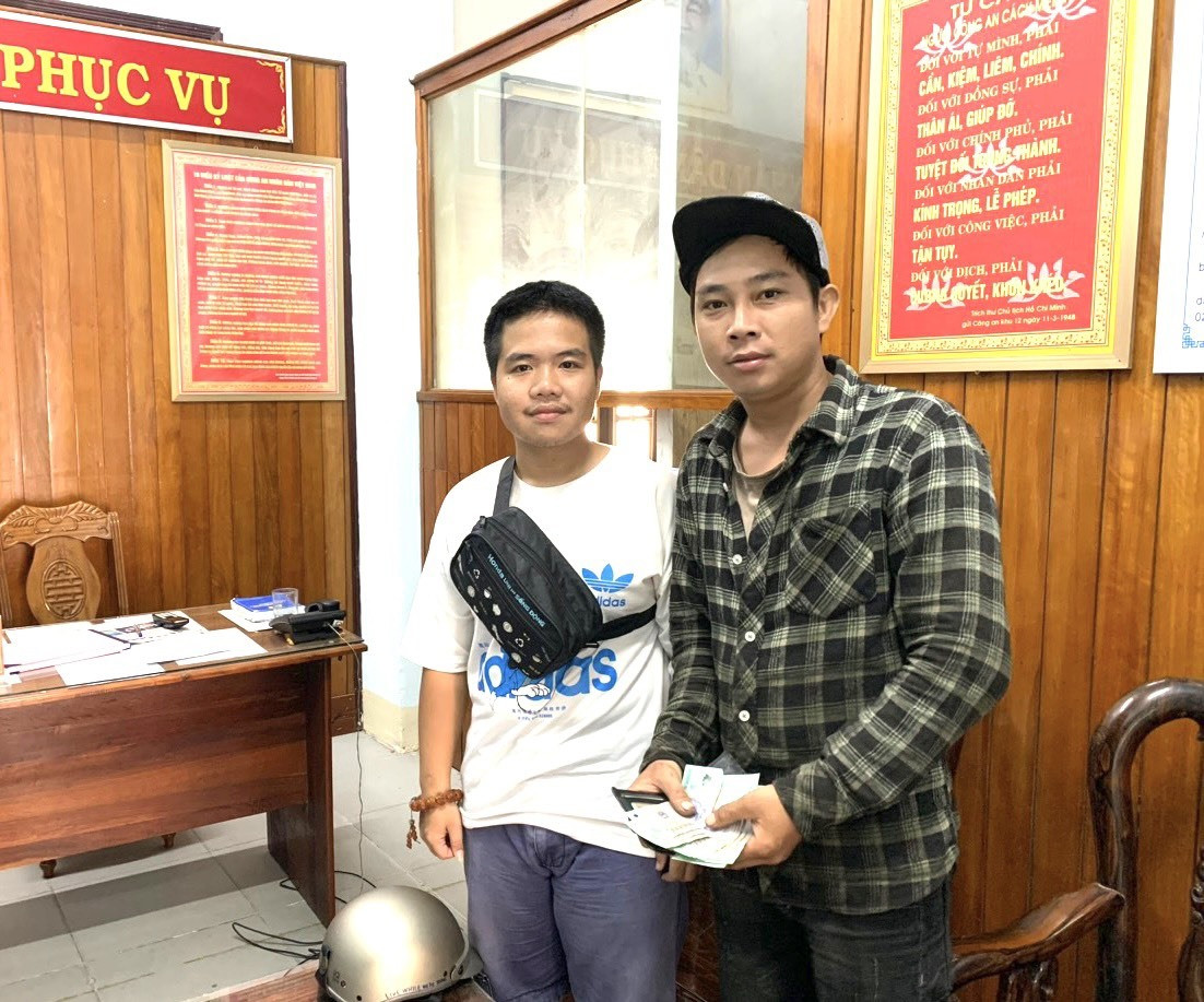 Anh Lê Minh Trí (áo trắng) trả lại tài sản cho cho anh Nghị tại trụ sở Công an TP.Tam Kỳ. Ảnh: Đ.D