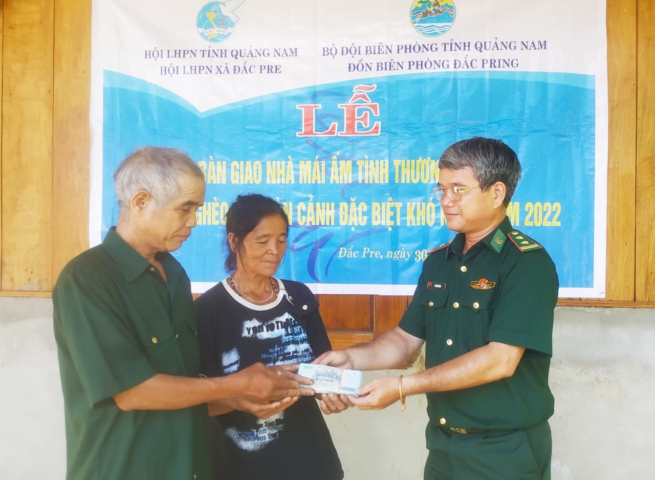 Đại diện lãnh đạo Đồn Biên phòng Đắc Pring trao tiền hỗ trợ xây dựng nhà “Mái ấm tình thương” cho hộ gia đình chị Hiên Thị Hưm.