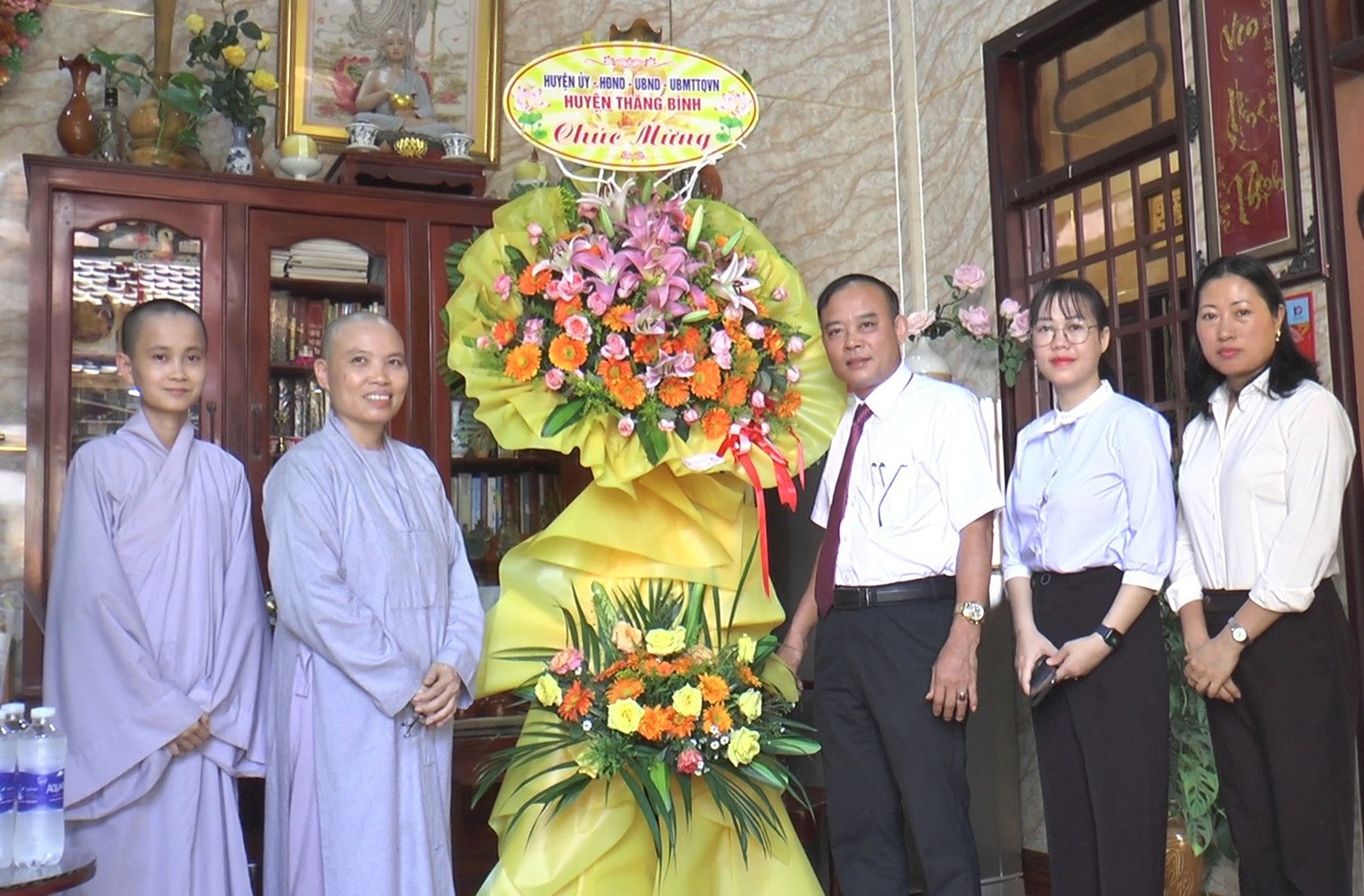 Ông Lê Quang Hạt, Phó Bí thư Thường trực Huyện ủy tặng hoa chúc mừng các tăng ni, phạt tử Chùa Bình Quế. Ảnh: Đ.H