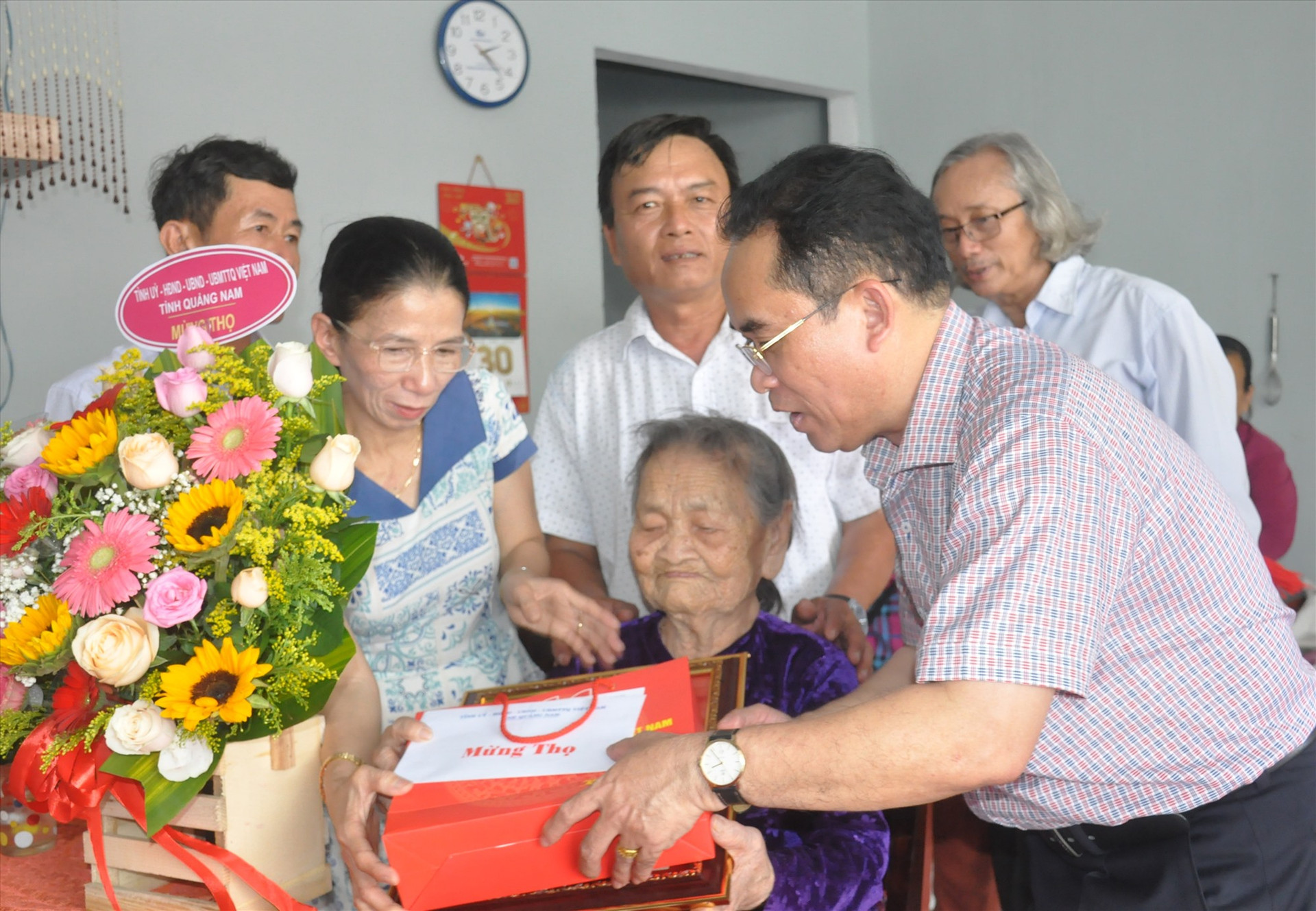 Phó Chủ tịch UBND tỉnh Trần Anh Tuấn tặng hoa, quà mừng thọ cụ Bùi Thị Nhung (thôn Cây Sanh, xã Tam Dân, Phú Ninh) tròn 100 tuổi. Ảnh: N.Đ