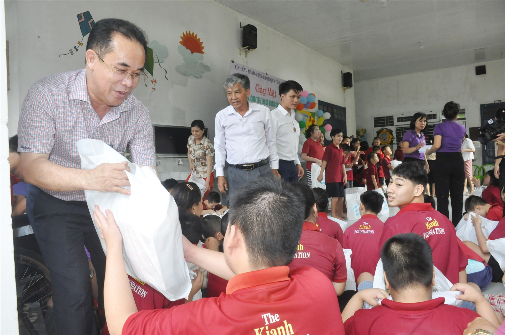 Phó Chủ tịch UBND tỉnh Trần Anh Tuấn tặng quà trẻ em khuyết tật đang được chăm sóc, nuôi dạy tại Trung tâm Nuôi dưỡng trẻ em khuyết tật Điện Bàn. Ảnh: N.Đ