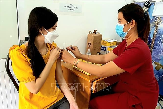 Tiêm vaccine phòng COVID-19 mũi nhắc lại cho người dân. Ảnh: TTXVN