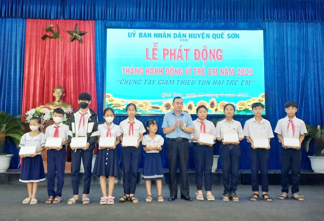 Lãnh đạo huyện Quế Sơn tặng quà cho trẻ em có hoàn cảnh khó khăn. Ảnh: DUY THÁI