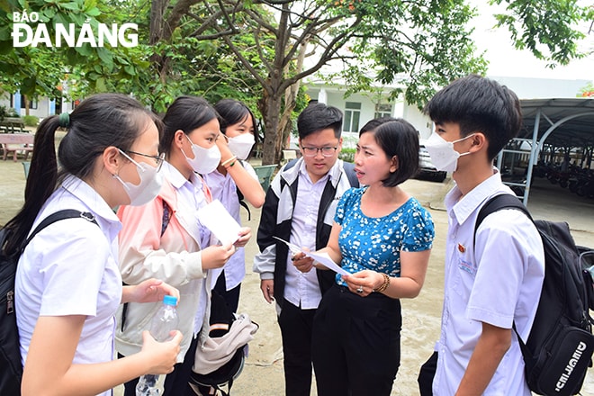 Thí sinh dự thi tại Trường THPT Ngũ Hành Sơn trao đổi với giáo viên sau môn thi đầu tiên.