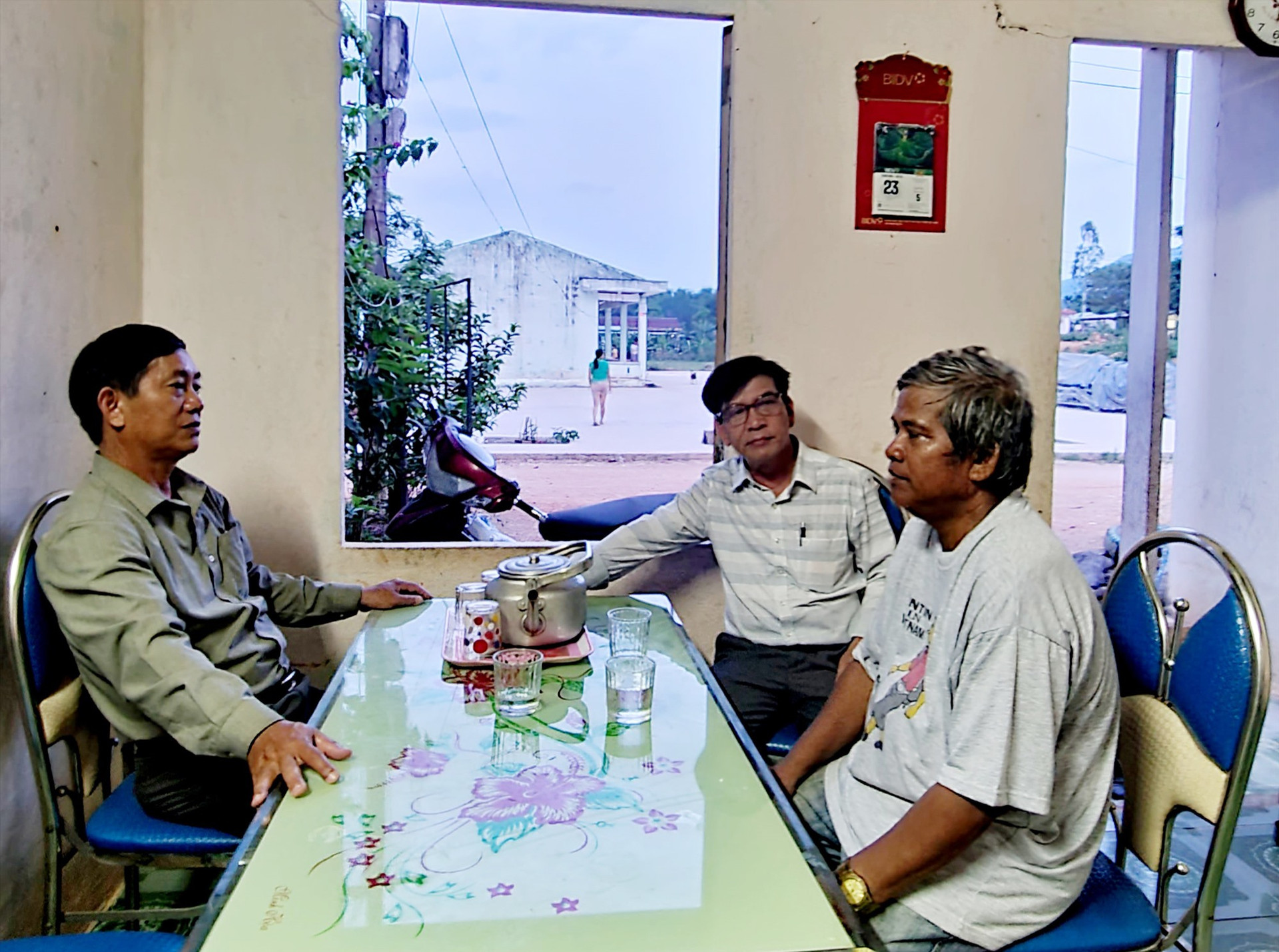 Ông Đinh Phe (bên phải) trò chuyện cùng lãnh đạo xã Đại Hưng tại làng Yều. Ảnh: HOÀNG LIÊN