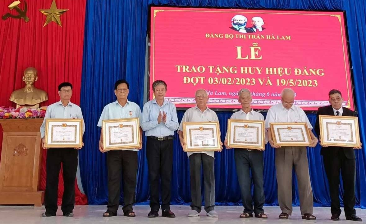 Ông Võ Văn Hùng, Phó Bí thư Huyện ủy- Chủ tịch UBND huyện trao Huy hiệu 55 năm tuổi Đảng cho các đảng viên. Ảnh: Đ.H