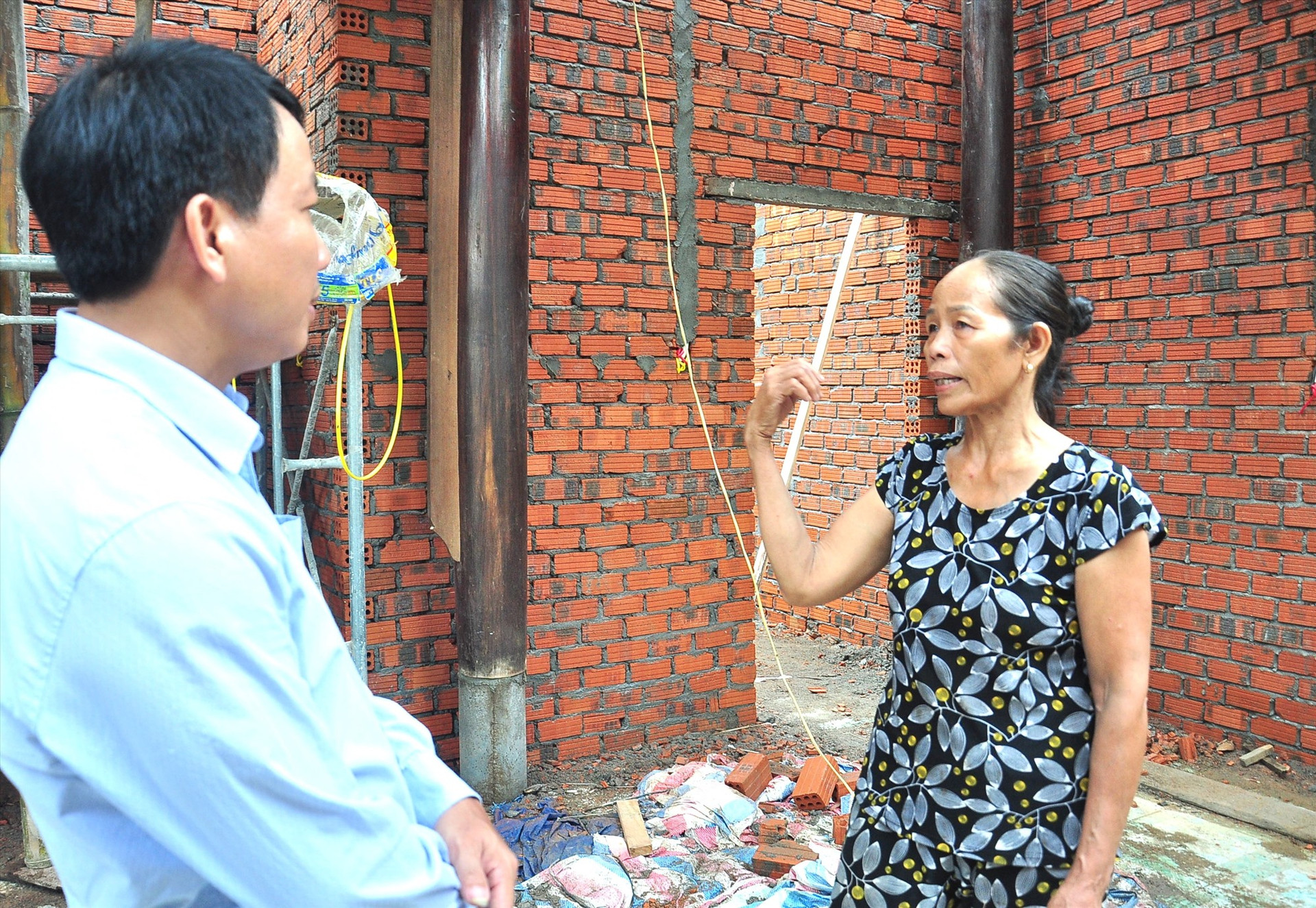 Bà Trần Thị Thọ nói chuyện với lãnh đạo Mặt trận xã Ninh Phước bên trong ngôi nhà của gia đình đang được xây dựng. Ảnh: PV