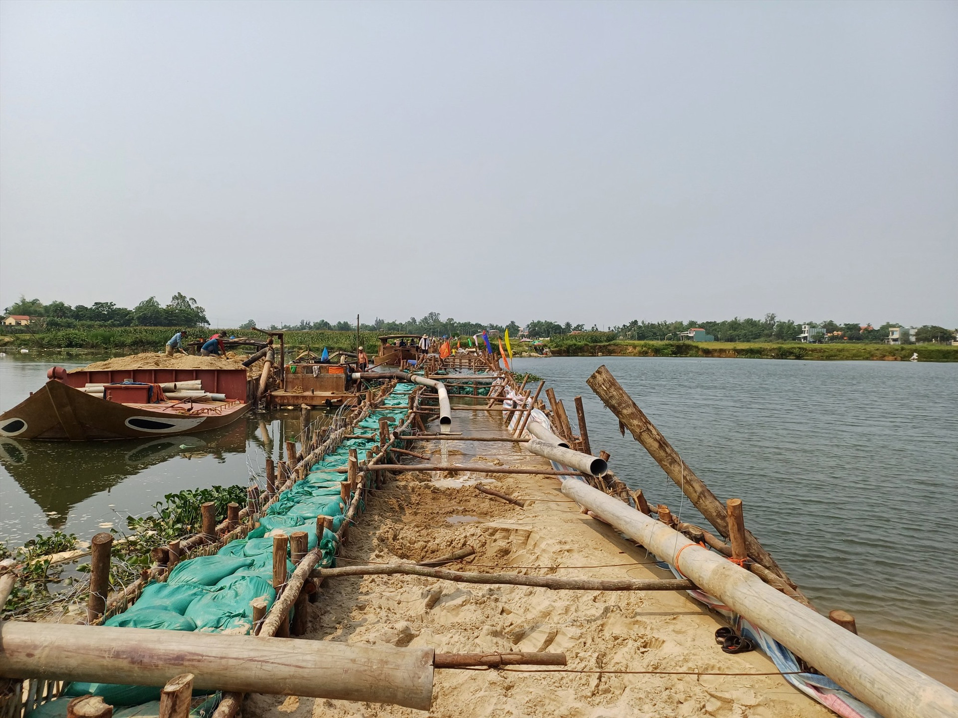 Đập tạm ngăn mặn, giữ nước ngọt trên sông Vĩnh Điện đã được UBND thị xã Điện Bàn và Công ty TNHH MTV Khai thác thủy lợi Quảng Nam thi công kịp thời đưa vào phục vụ cho vụ hè thu 2023. Ảnh: H.Đ
