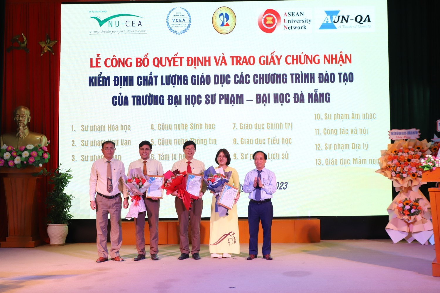 Giám đốc ĐHĐN Nguyễn Ngọc Vũ (bên phải) và Hiệu trưởng Nhà trường Lưu Trang (bên trái) tặng hao chúc mừng các khoa có 3 chương trình đạt chuẩn quốc tế AUN -QA. Ảnh Nhà trường cung cấp.
