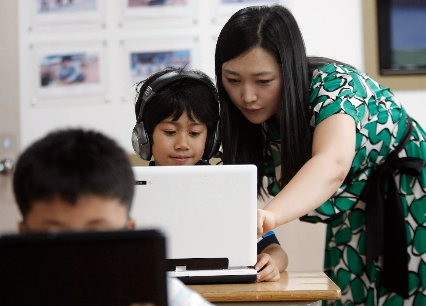 Giáo viên hướng dẫn học sính sử dụng công nghệ tại lớp học ở Hàn Quốc. Ảnh: AP