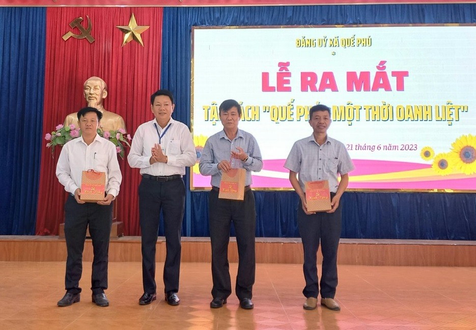 Ông Phan Duy Phương – Bí thư Đảng ủy xã Quế Phú tặng sách cho lãnh đạo huyện Quế Sơn. Ảnh: DUY THÁI