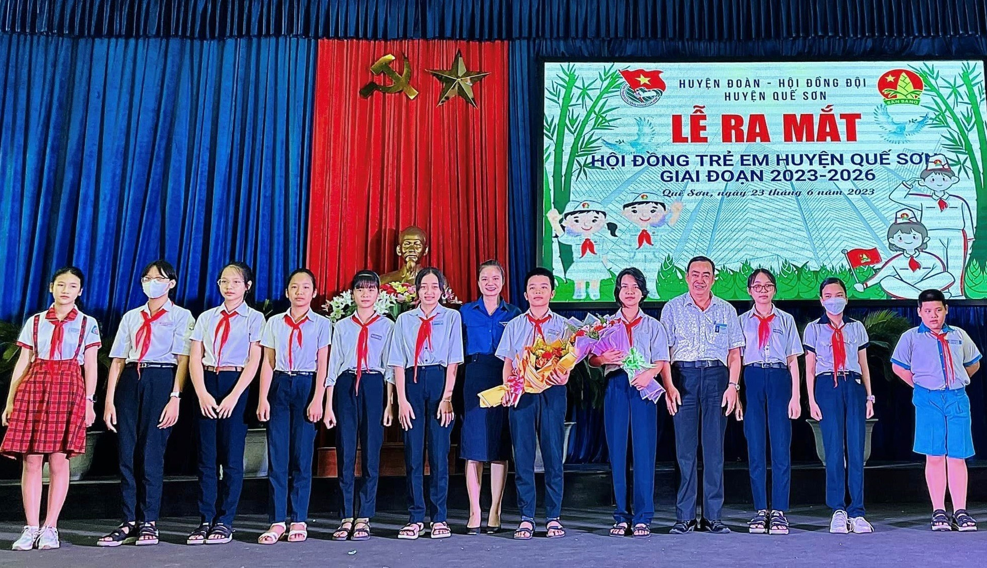 Lãnh đạo huyện tặng hoa chúc mừng Hội đồng trẻ em huyện Quế Sơn. Ảnh: A.T