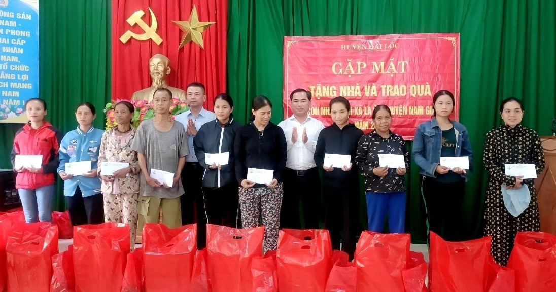 Chủ tịch UBND huyện Đại Lộc - ông Lê Văn Quang (đứng thứ 5 từ phải sang) trao quà cho hộ gia đình khó khăn trên địa bàn xã. Ảnh: X.TRINH