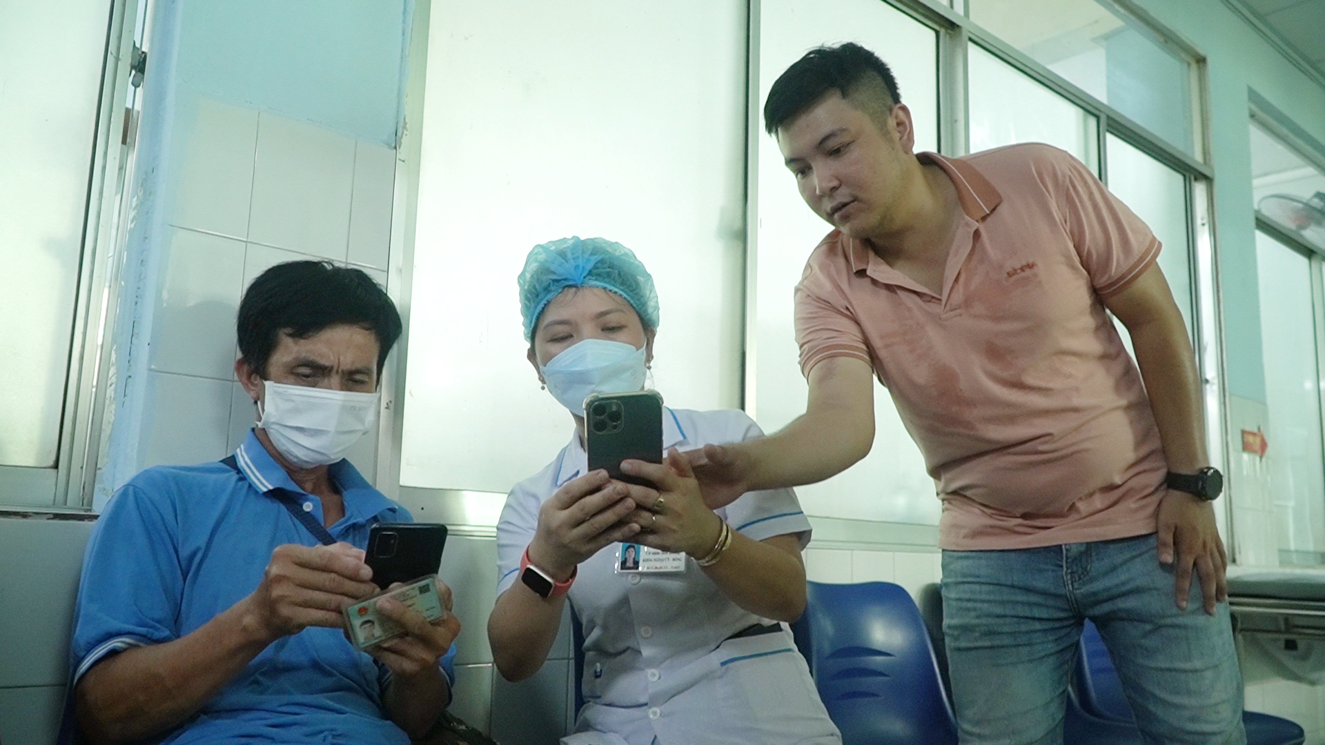 Nhân viên y tế hướng dẫn người dân khai báo lưu trú trên app VNeID. Ảnh: VĂN TOÀN