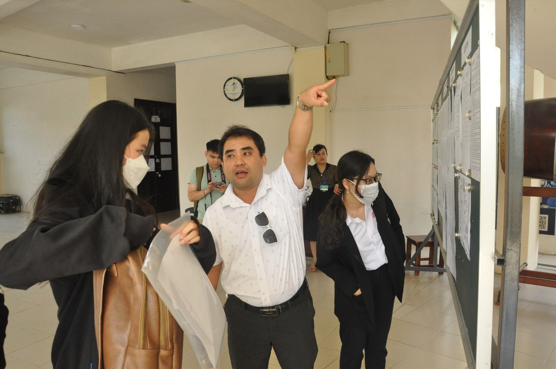 Cán bộ tại điểm thi Trường THPT chuyên Nguyễn Bỉnh Khiêm hướng dẫn sơ đồ phòng thi cho các thí sinh. Ảnh: X.P