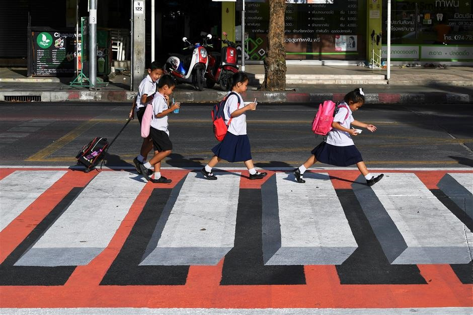 Học sinh ở Bangkok đi trên làn đường nổi 3D dành cho người đi bộ. Ảnh: Reuters