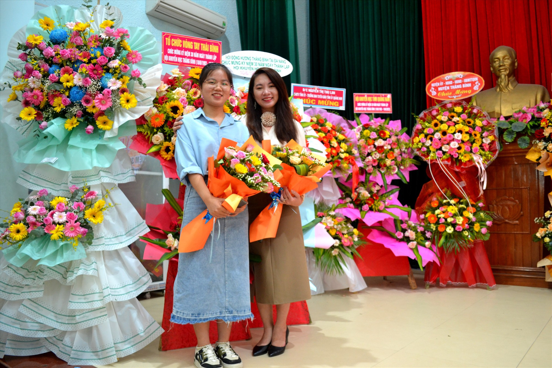 Nguyễn Thị Phương Thảo (trái) và Lê Thị Kiều My chụp ảnh chung tại buổi gặp mặt kỷ niệm 30 năm thành lập Hội Khuyến học Thăng Bình diễn ra ngày 9/6. Ảnh: VIỆT NGUYỄN