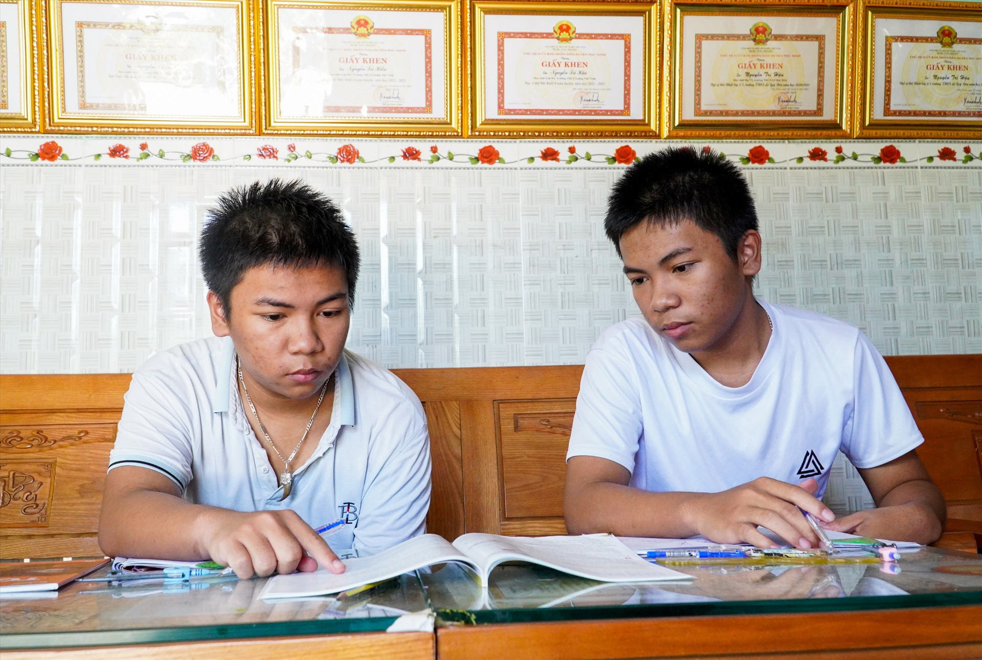 Hai anh em Nguyễn Trí Hiền - Nguyễn Trí Hậu đang say mê giải bài tập Toán lớp 10. Ảnh: H.Q