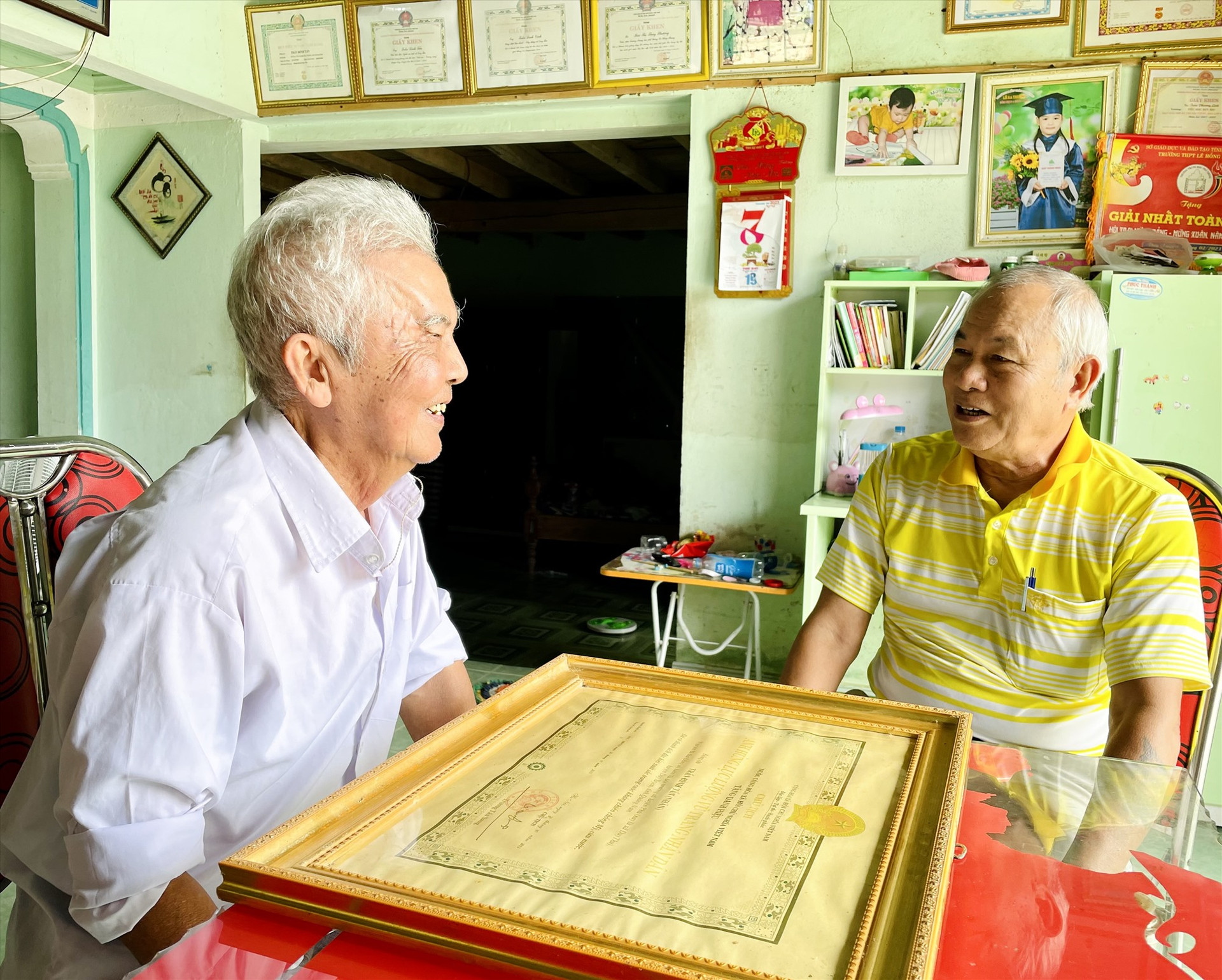 Anh hùng Lực lượng vũ trang nhân dân Trần Đình Tẩn (áo trắng, bên trái) và cựu tù Phú Quốc - Hoàng Ngọc Thanh ôn lại những tháng ngày chiến đấu gian khổ, ác liệt.