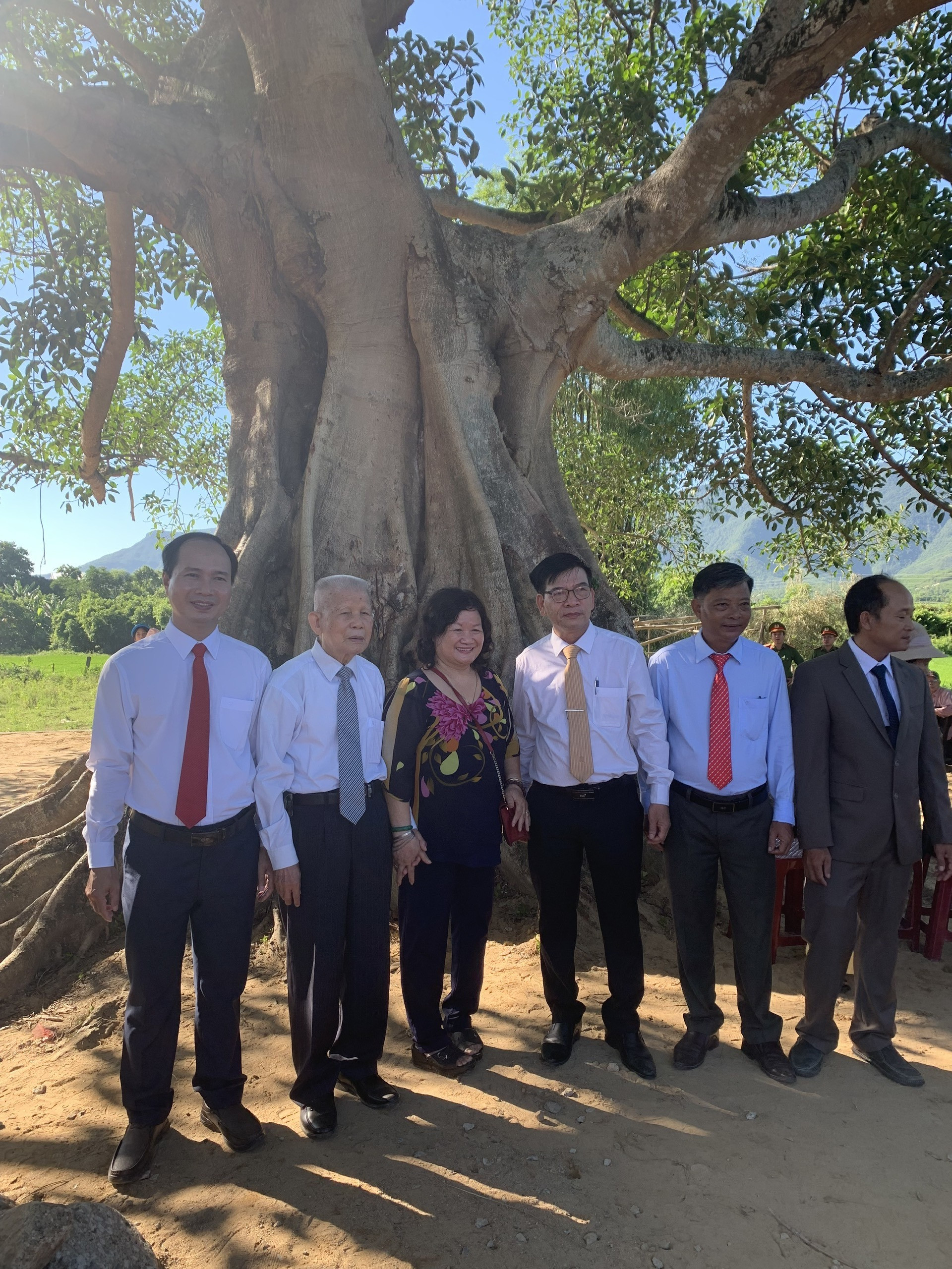 GS.TSKH Đặng Huy Huỳnh cùng lãnh đạo địa phương chụp ảnh lưu niệm bên cây di sản. Ảnh: H.L