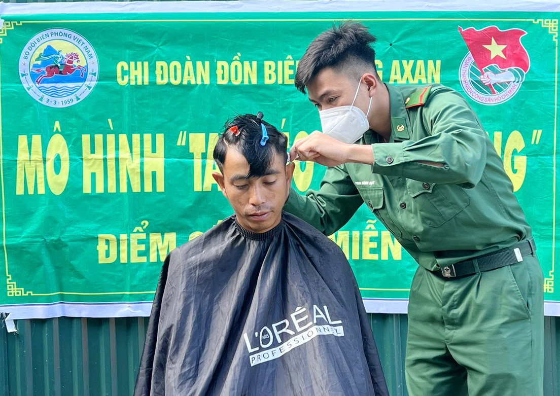 Chiến sĩ Đồn Biên phòng A Xan cắt tóc cho Trung úy Khăm Min Đuông Vị Lay Sản - Đại đội phó Đại đội Biên phòng 534 khi sang hội đàm và tuần tra song phương. Ảnh: B.P