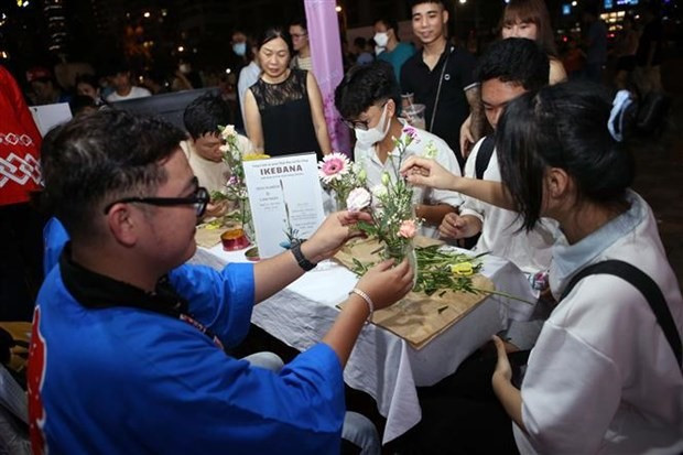 Visitors experience the Japanese art of flower arrangement at the festival. (Photo: VNA)