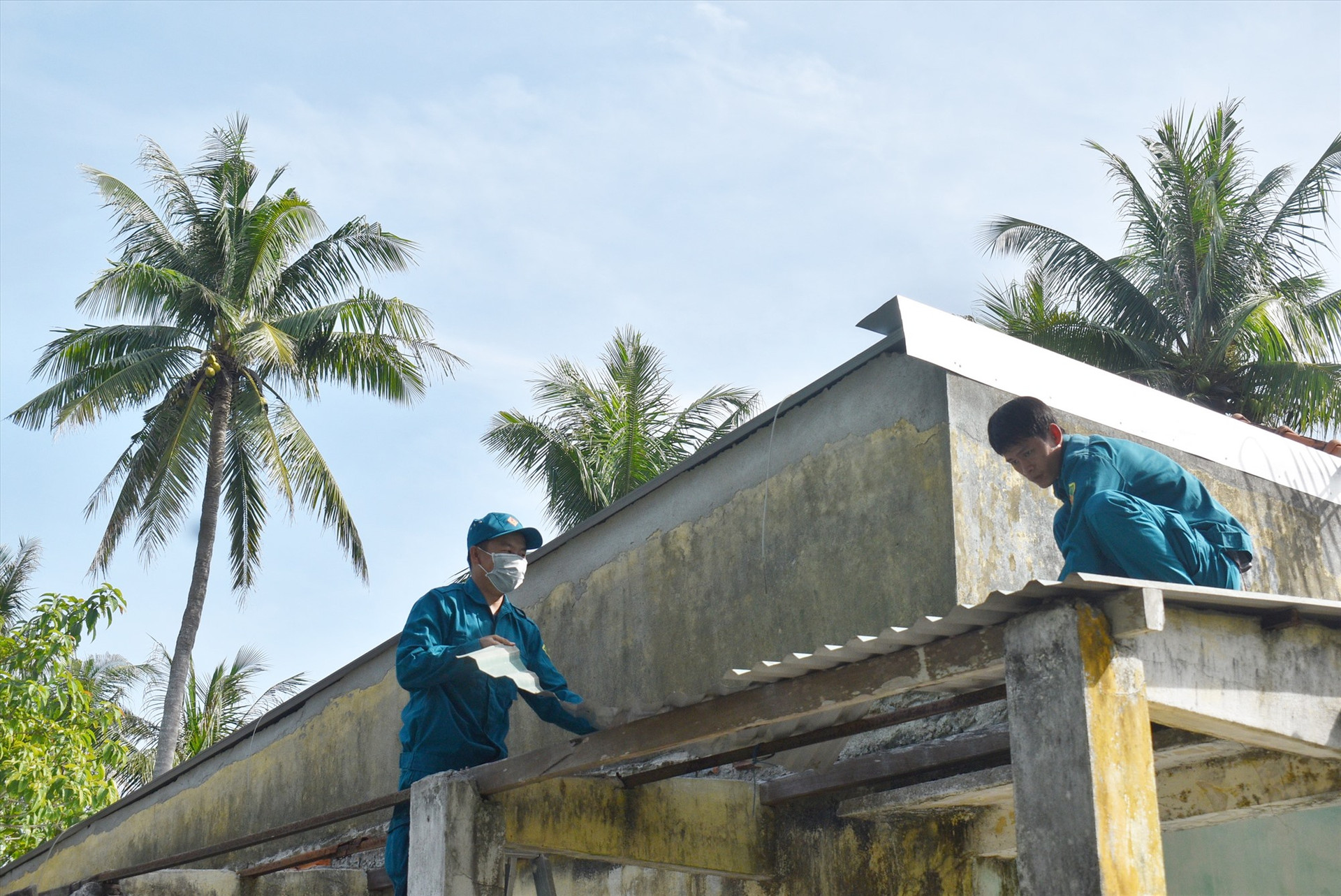 Lợp lại chái nhà bằng tôn. Ảnh: N.Q