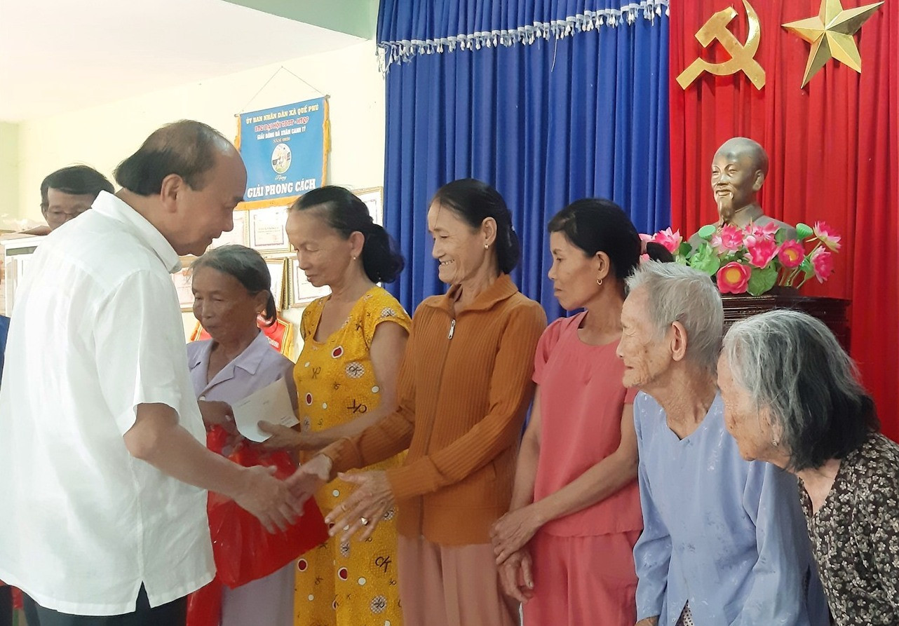 Nguyên Chủ tịch nước Nguyễn Xuân Phúc tặng quà cho các gia đình chính sách tiêu biểu và có hoàn cảnh khó khăn. Ảnh: N.S