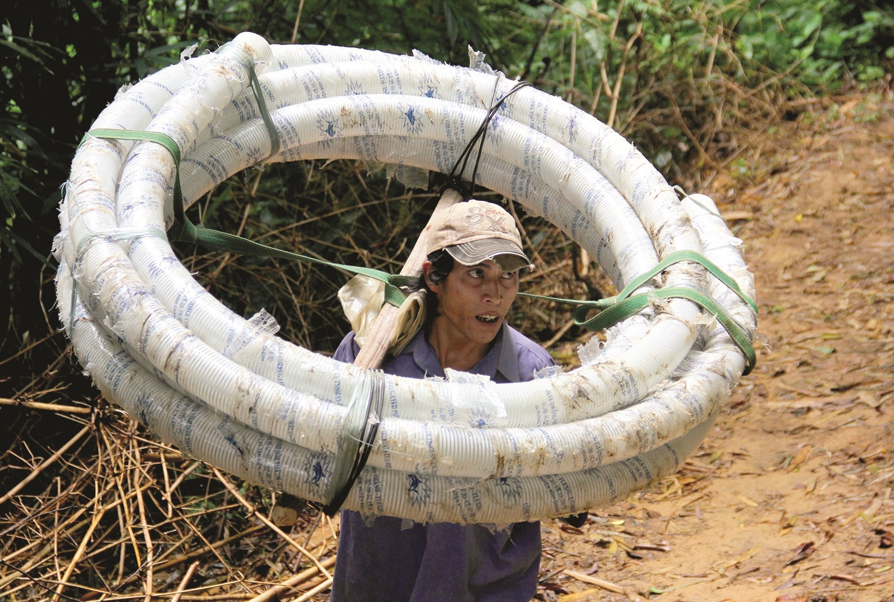 Hồi chưa có đường, người đàn ông này phải ngược núi rất vất vả để khiêng cuộn ống nhựa về lắp đặt đường dẫn nước sinh hoạt cho gia đình.