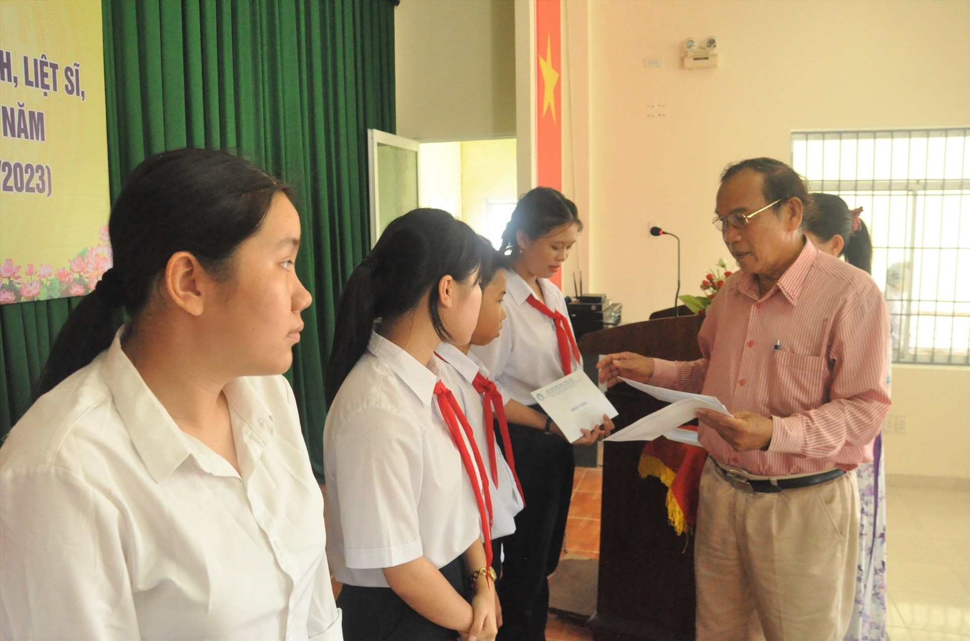 Chủ tịch Hội Khuyến học tỉnh Trần Văn Cận trao học bổng cho các em. Ảnh: X.P