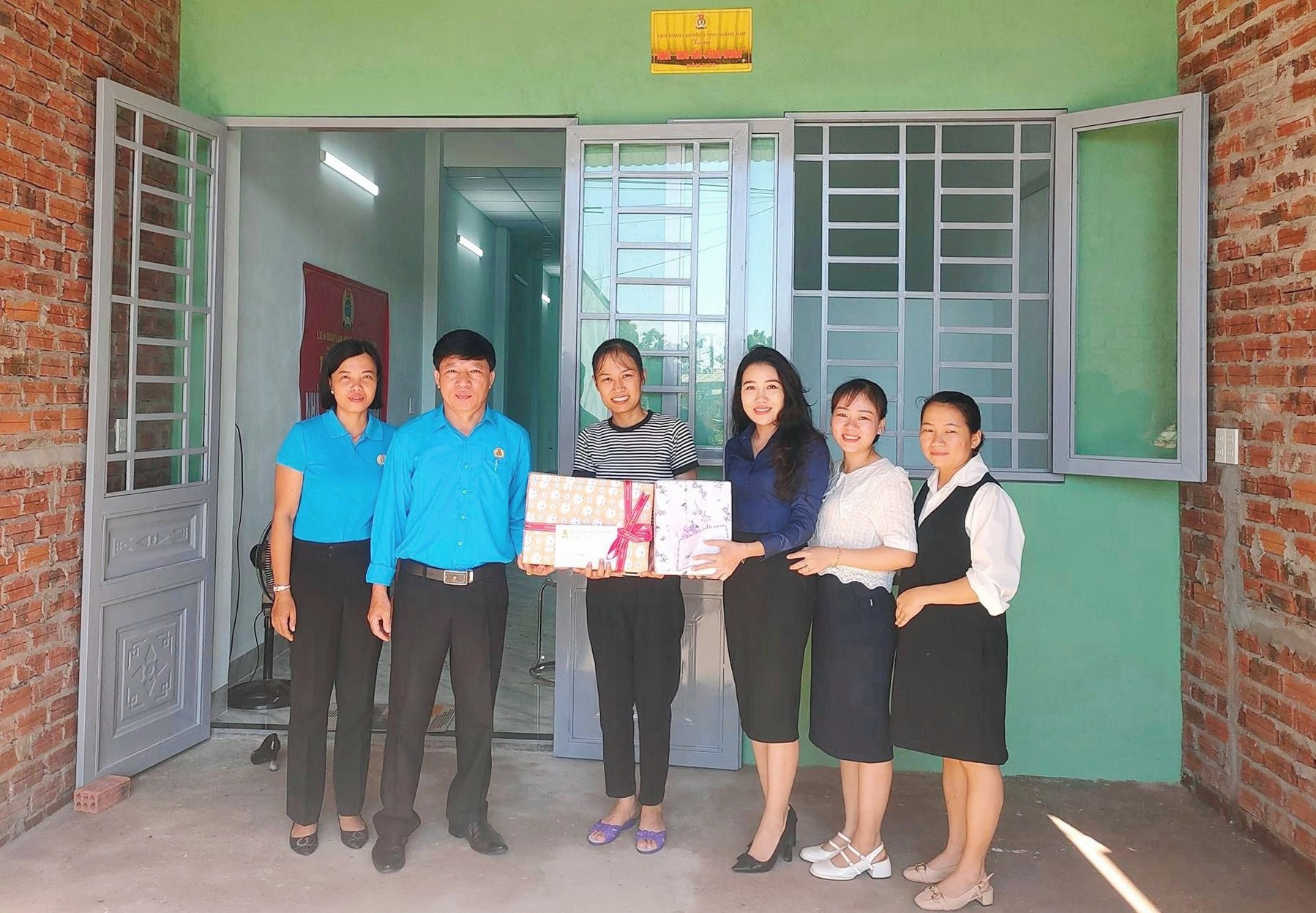 Lãnh đạo Liên đoàn lao động TX Điện Bàn tặng quà chúc mừng đoàn viên Nguyễn Thị Chính có ngôi nhà mới khang trang.