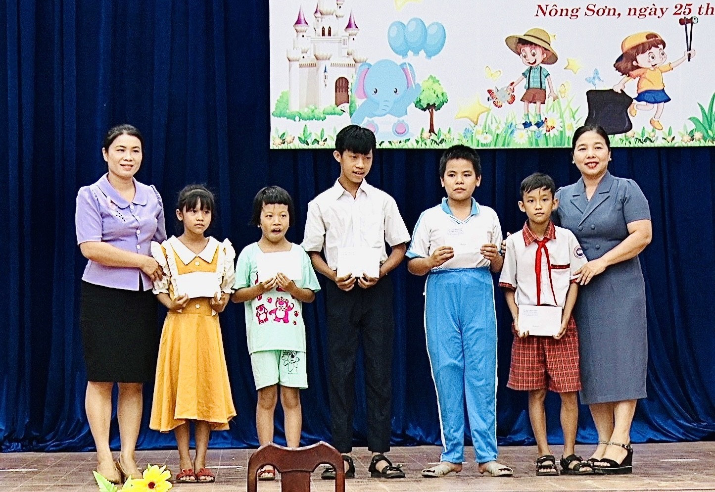 Lãnh đạo huyện Nông Sơn tặng quà cho trẻ em có hoàn cảnh đặc biệt khó khăn. Ảnh: MINH TÂM