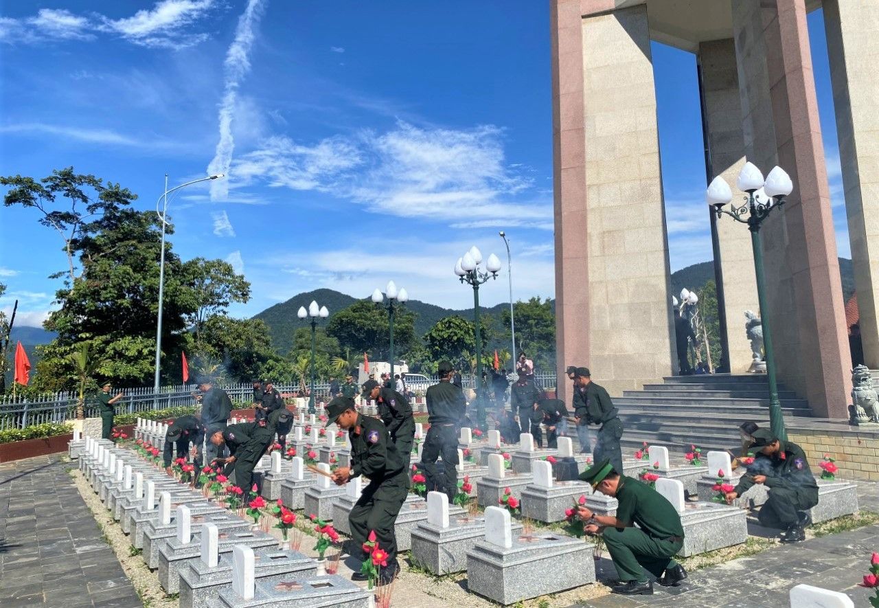 Các lực lượng công an, quân đội thắp hương tại mộ bia các liệt sĩ tại nghĩa trang huyện. Ảnh: N.B