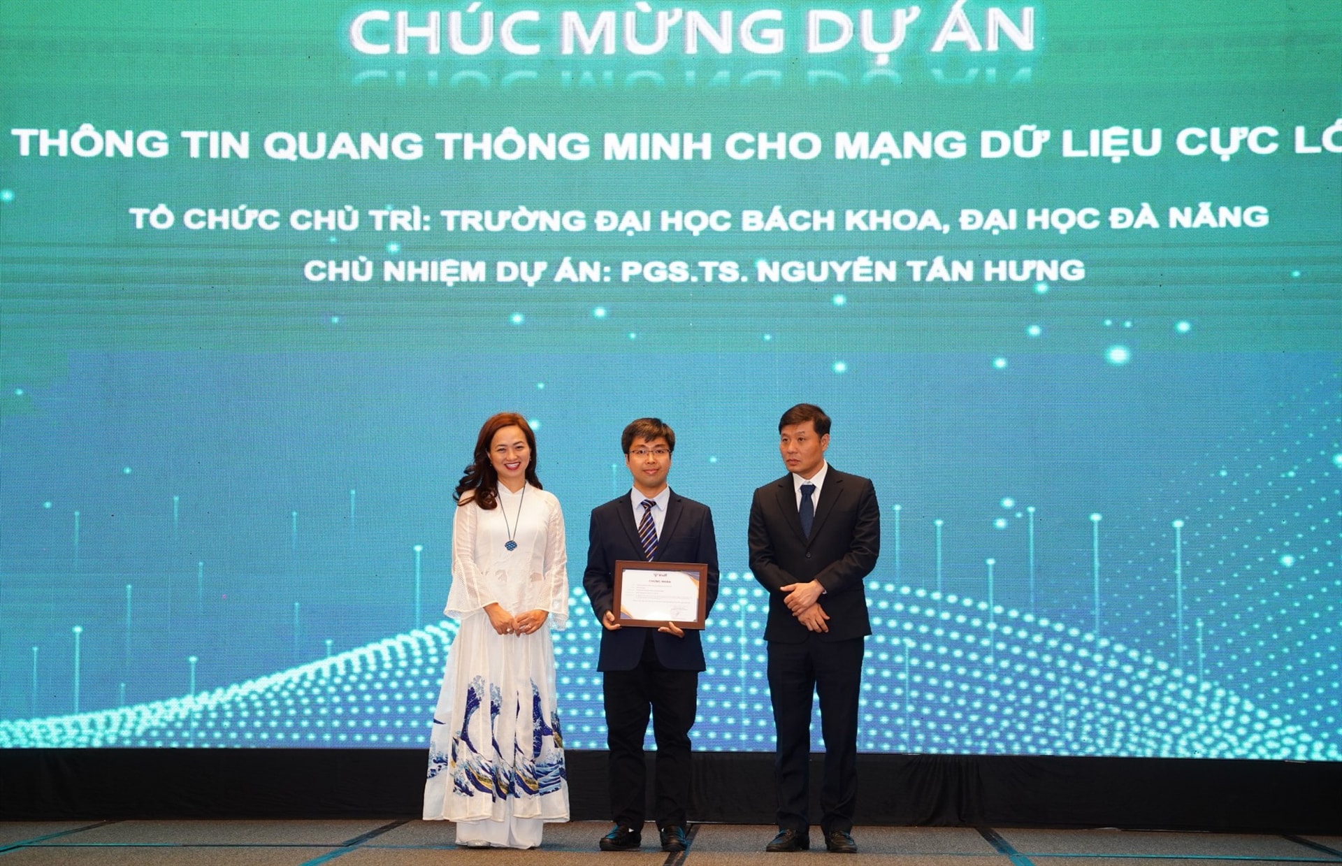 GS.Vũ Hà Văn trao Giấy chứng nhận hoàn thành cho dự án “Thông tin quang thông minh cho mạng dữ liệu cực lớn” của ĐH Đà Nẵng. Ảnh ĐHĐN