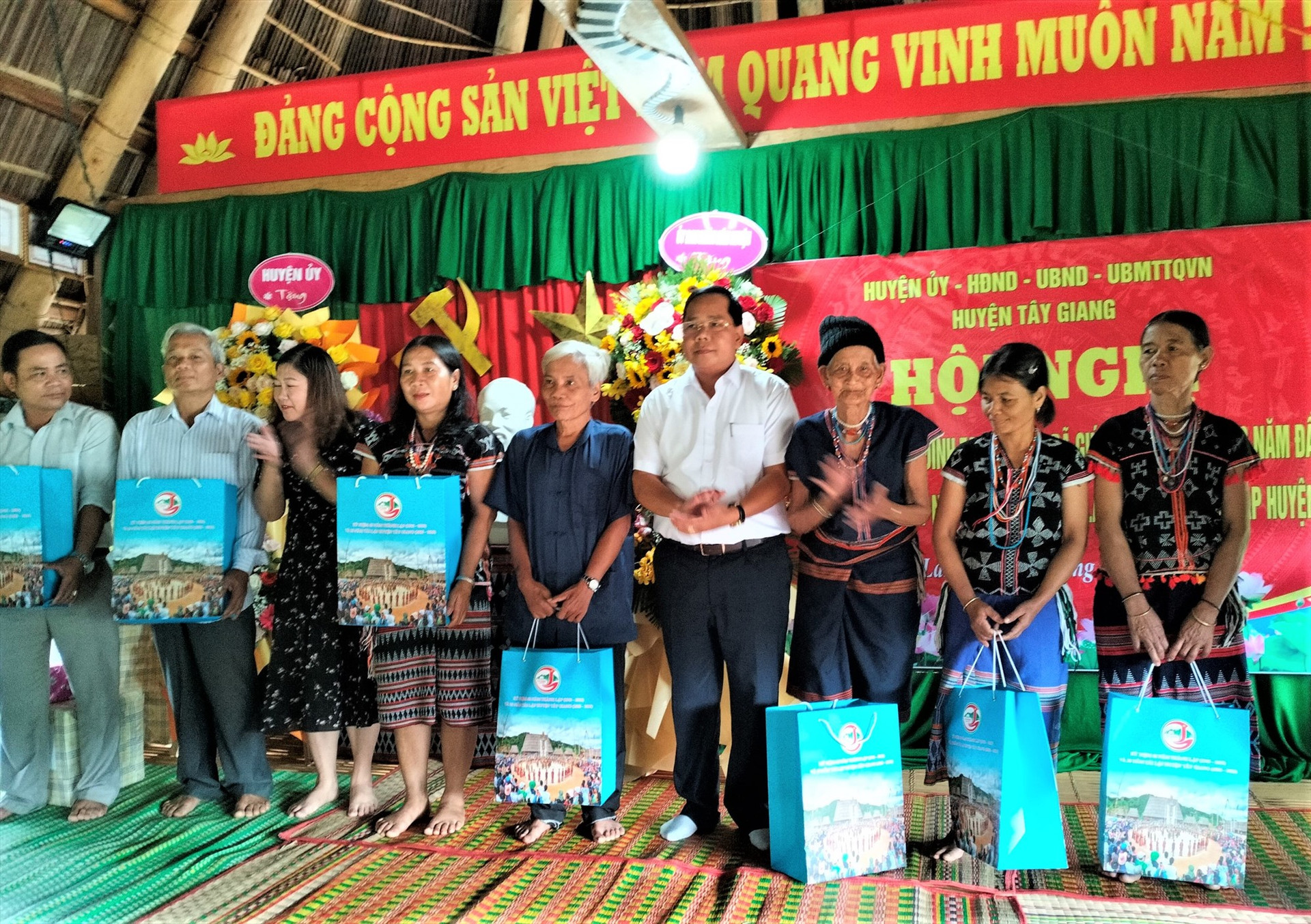 Bí thư Huyện ủy Tây Giang Bhling Mia (thứ tư, từ phải sang) trao quà động viên các hộ dân giúp đỡ địa phương những ngày đầu tái lập. Ảnh: Đ.N