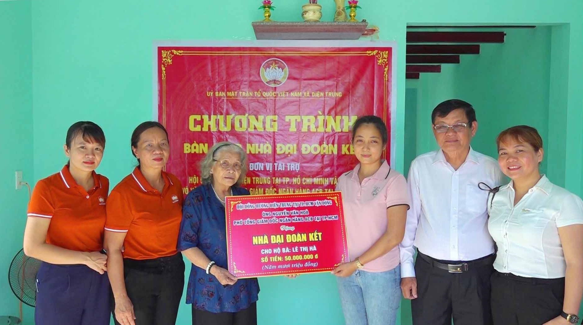 Đại diện Hội đồng hương Điện Trung tại thành phố Hồ Chí Minh và nhà tài trợ trao bảng tượng trưng cho gia đình chị Nguyễn Thị Hà.