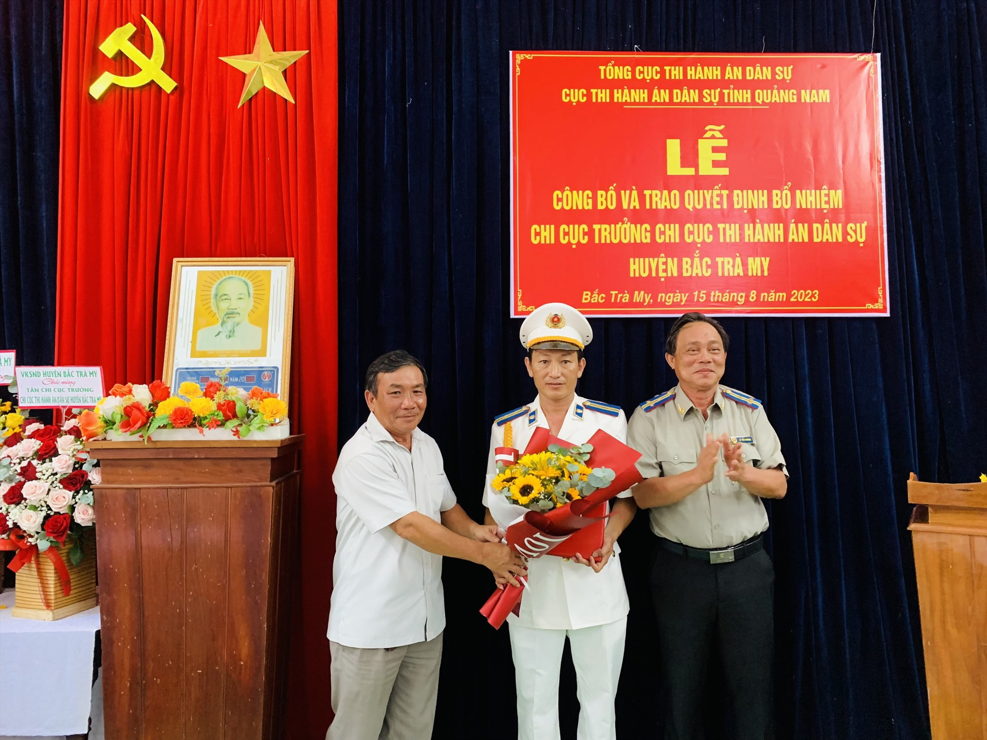 Lãnh đạo cục thi hành án dân sự tỉnh Quảng Nam và lãnh đạo huyện Bắc Trà My trao Quyết định, tặng hoa chúc mừng. ẢNH TÚ VÂN