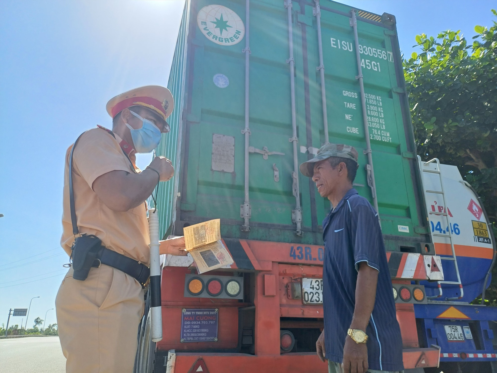 Cán bộ Đội CSGT số 1 kiểm tra một xe container chạy trên tuyến đường tránh Nguyễn Hoàng. Ảnh: C.Q