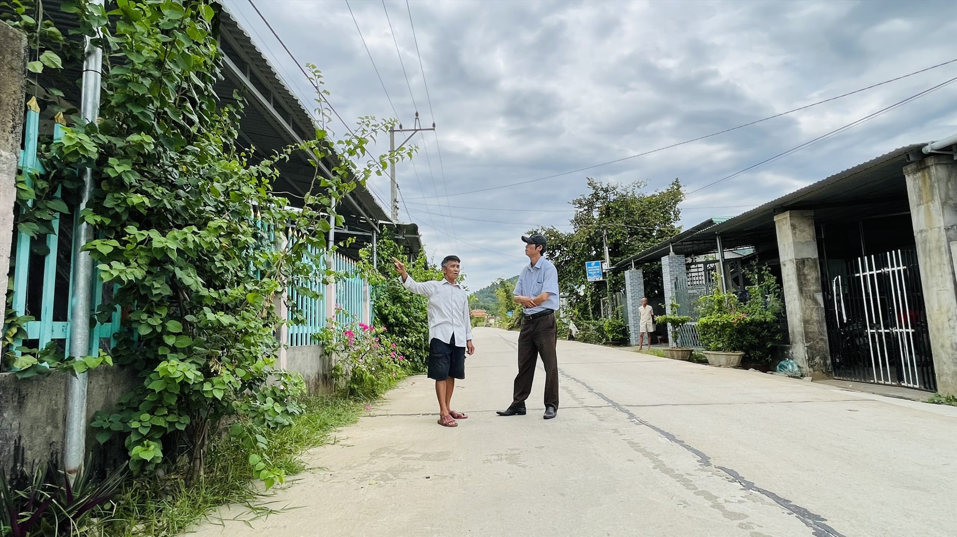 Ông Nguyễn Dũng (bên trái) trên khu đất gia đình hiến để mở rộng tuyến đường ĐH 28. Ảnh VĂN TOÀN