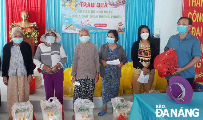 Ông Trần Vinh (bên phải) trao quà cho người nghèo của thôn Hưởng Phước (xã Hòa Liên)nhân dịp Tết Nguyên đán. Ảnh: T.V