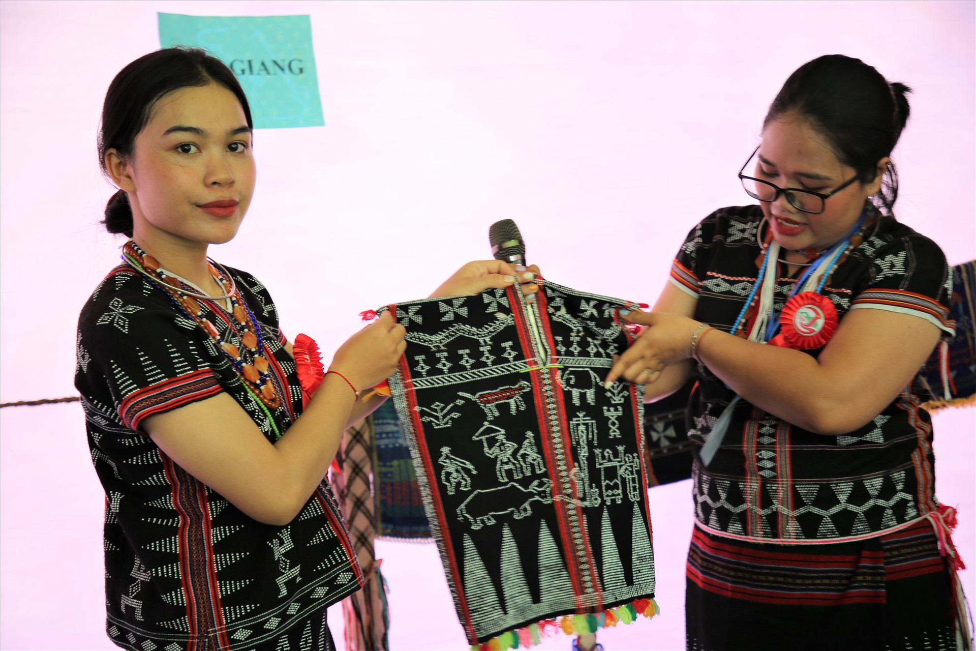 Thiếu nữ Cơ Tu ở huyện Tây Giang giới thiệu sản phẩm dệt độc đáo được làm ra từ quá trình sáng tạo của nghệ nhân địa phương. Ảnh: H.Đ.G