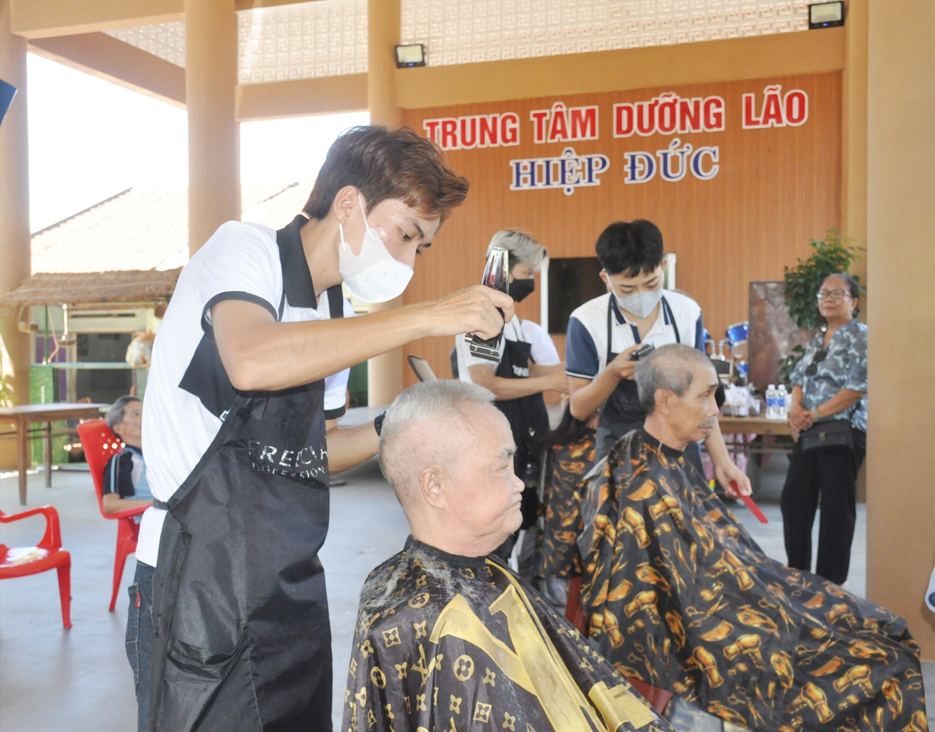 Các tình nguyện viên đến cắt tóc miễn phí cho các cụ già sáng nay 18/8. Ảnh: N.Đ
