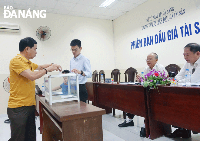 Việc đấu giá thuê mặt bằng có thời hạn tại các khu đất lớn thu hút sự quan tâm của nhiều người dân, tổ chức. Trong ảnh: Người đấu giá bỏ phiếu đấu giá trực tiếp để thuê mặt bằng một khu đất trong tháng 7-2023. Ảnh: HOÀNG HIỆP