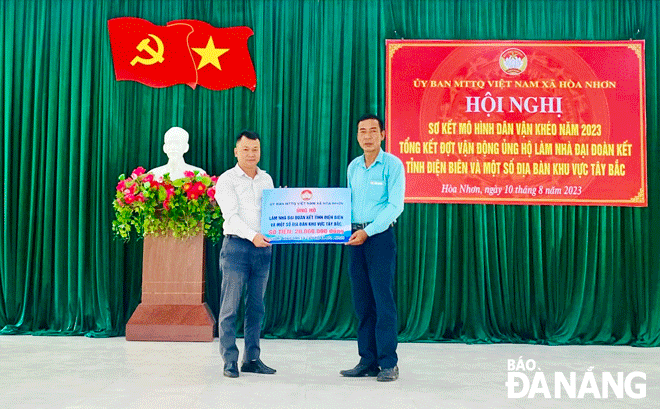 Chủ tịch Ủy ban MTTQ Việt Nam xã Hòa Nhơn Nguyễn Đình Thu (bên phải) trao ủng hộ xây nhà “Đại đoàn kết “ cho người nghèo tỉnh Điện Biên. Ảnh: H.N