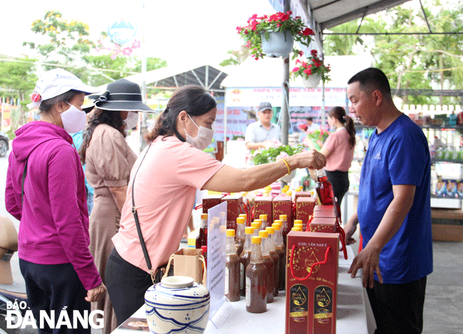 Các đơn vị, địa phương đã tổ chức nhiều chương trình, sự kiện nhằm hỗ trợ, tạo điều kiện để các bà con trong làng nghề nước mắm truyền thống Nam Ô phát triển bền vững. Trong ảnh: Người dân, du khách chọn mua sản phẩm nước mắm Nam Ô tại phiên chợ nông sản huyện Hòa Vang. Ảnh: VĂN HOÀNG